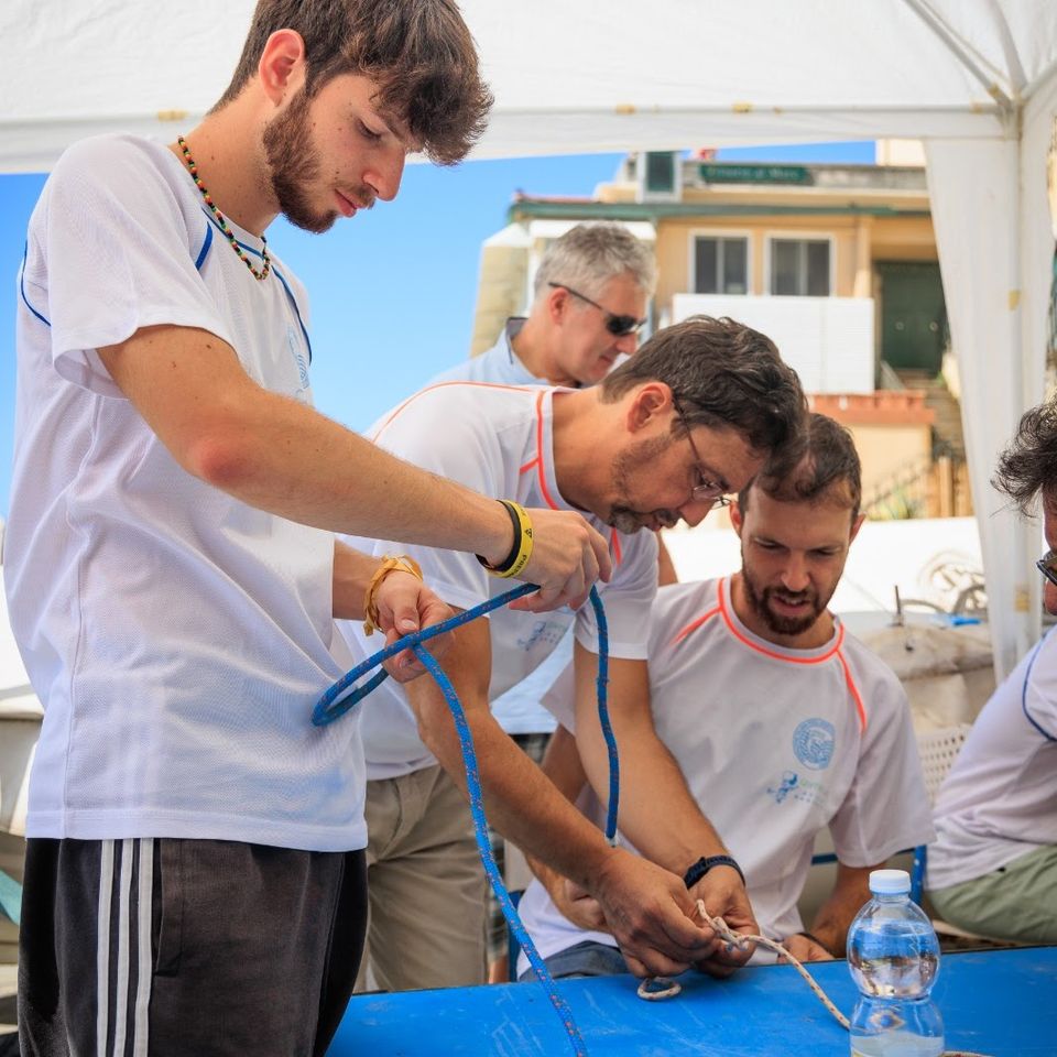 allievi e istruttori intenti nell'apprendere l'arte dei nodi, primo piano